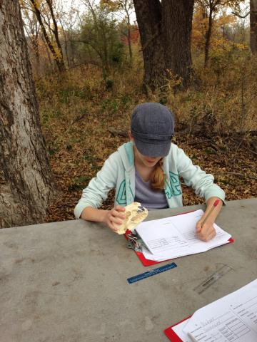 child working on paper at picnic table